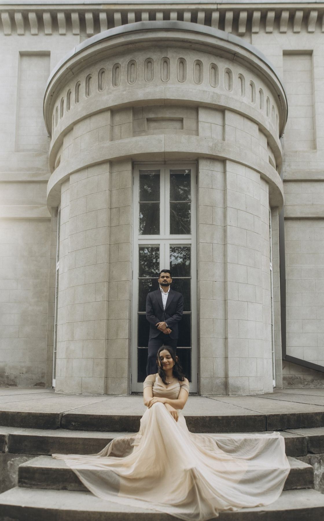 Rutva in a champagne gown on the rotunda steps, Nitin in a dark suit, e-shoot styled by Bhoomi Jani Weddings