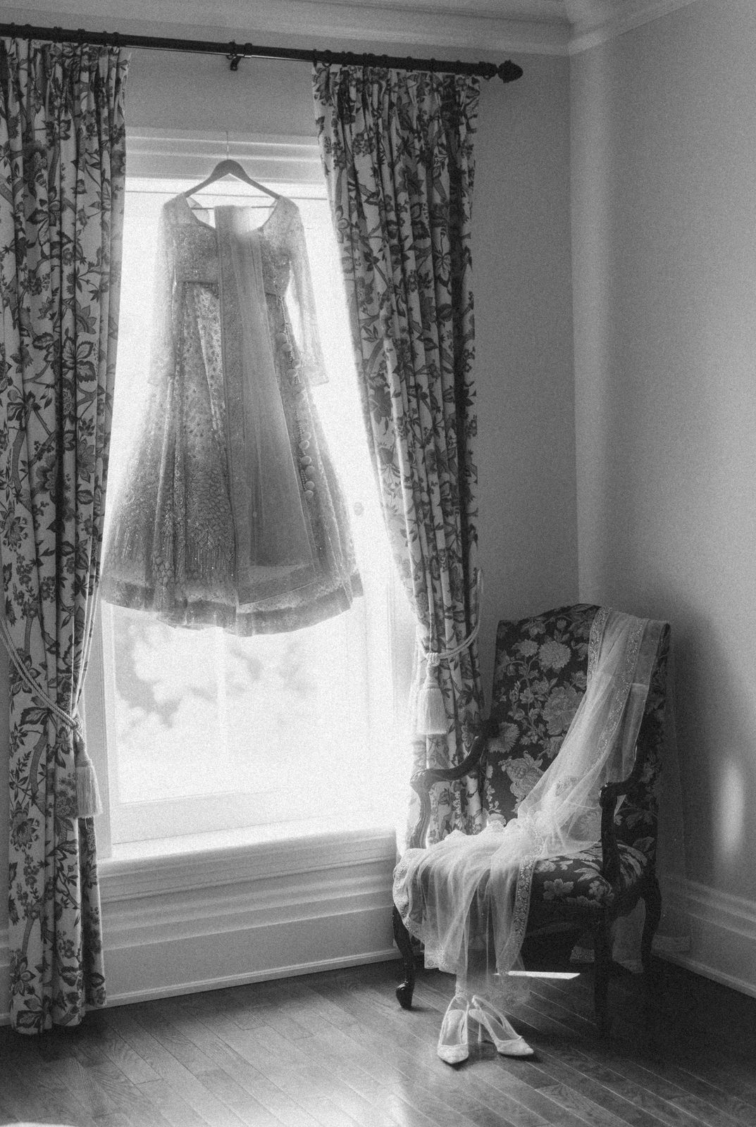 Embroidered bridal lehenga and dupatta hanging in a window before a South Asian wedding, styling by Bhoomi Jani Weddings, Greater Toronto Area